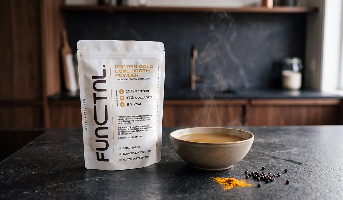 Mug of frothed halal bone broth beside a pouch of Halal Bone Broth powder